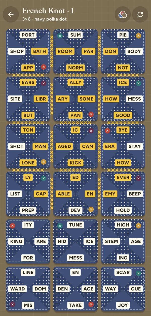 A tall French Knot board, three blocks across and six down, half stitched together with gold cross-stitches